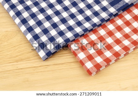 Red and blue checked tablecloth on wooden background