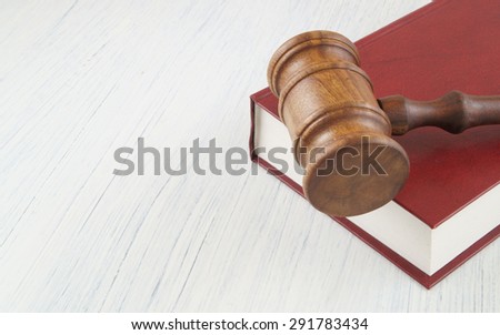 Judge\'s wooden gavel on red legal book with room for text