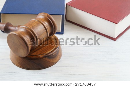 Judge\'s gavel and blue and red legal books