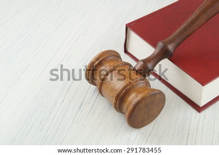 Wooden judge\'s gavel on red legal book
