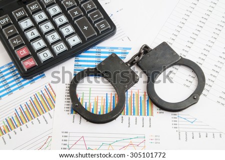 Financial fraud concept, calculator and handcuffs on financial documents