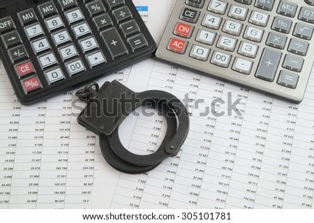 Financial fraud concept, calculators and handcuffs on financial documents