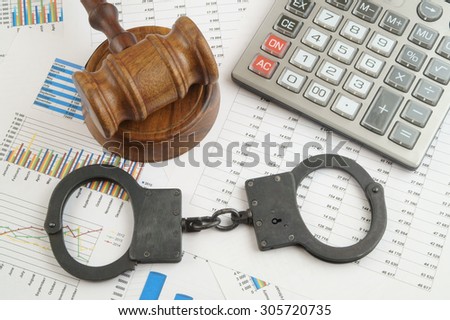 Financial fraud concept, judge gavel, calculator and handcuffs on financial documents