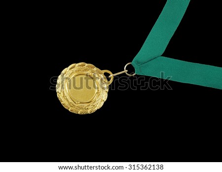 Gold medal with green ribbon isolated on black background