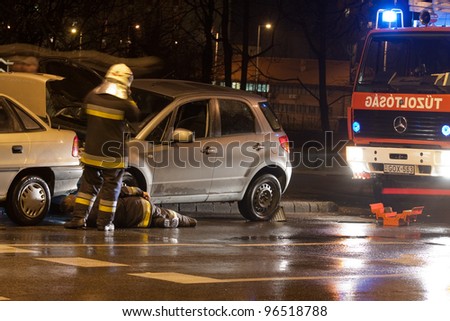 PECS, HUNGARY - DEC. 01: car crashed. Firefighter try to help the victim of car accident on Dec. 01, 2010 on Road 6 in Pecs, Hungary.