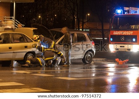 PECS, HUNGARY - DEC. 01: Firefighters try to help the victim of car accident on Dec. 01, 2010 on Road 6 in Pecs, Hungary.