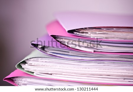 Photograph illustrating a stack of files to be processed.