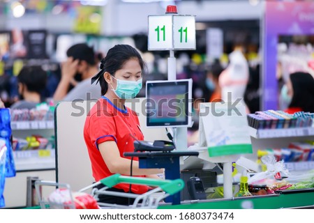 Cashier or supermarket staff in medical protective mask working at supermarket.covid-19 spreading outbreak  