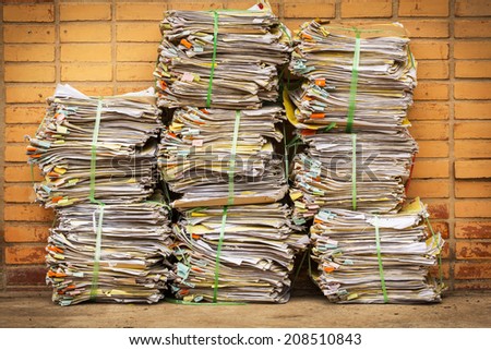 old document piles tied with plastic rope on brick background