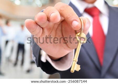 businessman showing the golden key to success