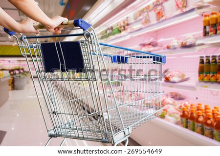 woman pushing shopping cart in grocery store