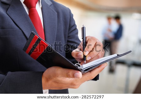 businessman writing a note in office