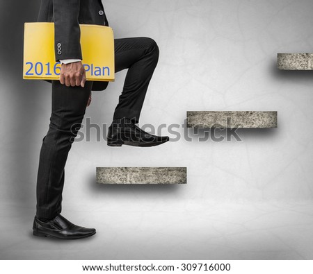 Businessman holding 2016 plan files and stepping up on stairs to success concept