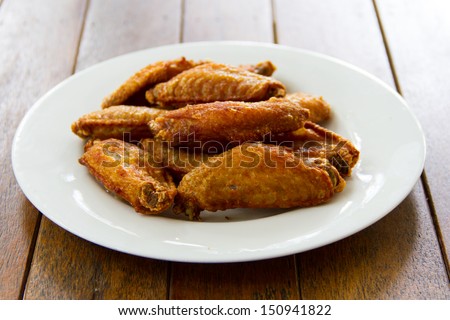 Chicken wings Fried in white dish on wooden table