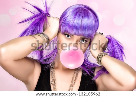 Portrait of beauty party girl with purple wig and pink bubble gum