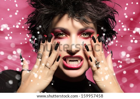 Vampire. Beautiful portrait of young woman with fancy makeup, fangs and wolf lenses
