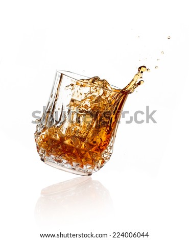 Whiskey toast. whiskey on glass of cut glass over white background