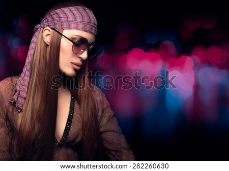 Fashion Beauty. Beautiful Party Girl with Healthy Long Brown Straight Hair, Wearing Brown Dress, Bandanna and Sunglasses in Hippie Style. Close up Portrait on  Abstract Background with Copy Space.