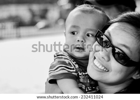 Black and white portrait of mother and child. Shallow dof, selective focus on the mother face.