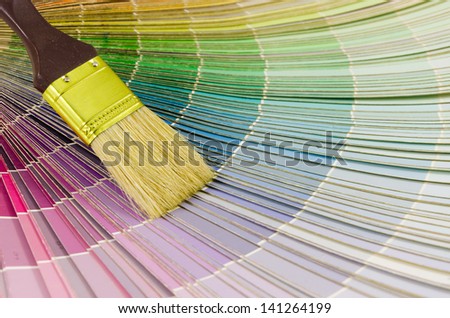 A paint brush and colorful paint swatches