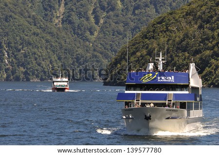 MILFORD SOUND, NEW ZEALAND, JANUARY 8: Visitors enjoy the view from a tourist launch on January 8, 2011 at Milford Sound, New Zealand. Milford is one of the country\'s favourite tourist destinations.