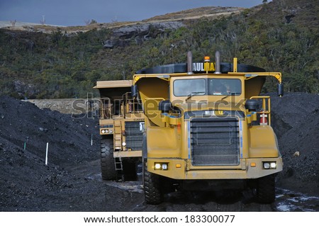 WESTPORT, NEW ZEALAND, July 20, 2009: 70 ton trucks cart coal from a stockpilel at Stockton Coal Mine near Westport, New Zealand