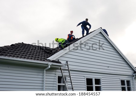 GREYMOUTH, NEW ZEALAND, APRIL 17, 2014: Volunteer workers assess work to be done on a house de-roofed in Cobden by Cyclone Ita, Greymouth, New Zealand, April 17, 2014