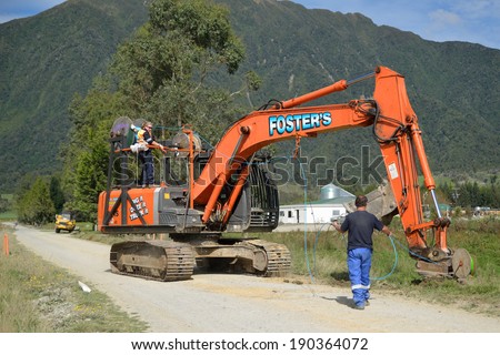 GREYMOUTH, NEW ZEALAND, APRIL 1, 2014: Workers lay a fibre optic cable as part of a government scheme to bring high-speed internet connections to rural Westland, New Zealand