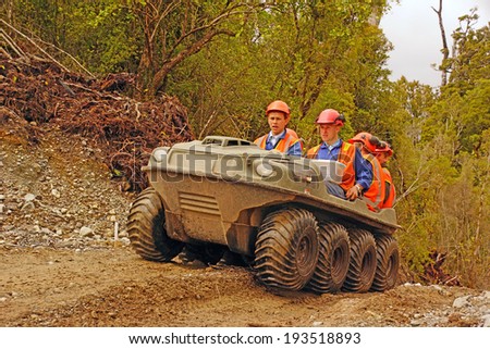 GREYMOUTH, NEW ZEALAND, 23-12-2013: Unidentified men travel in an all terrain vehicle while working in the bush on the West Coast of New Zealand
