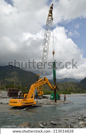 GREYMOUTH, NEW ZEALAND, CIRCA DECEMBER 2013: Builders construct a concrete bridge over a small river in Westland, New Zealand