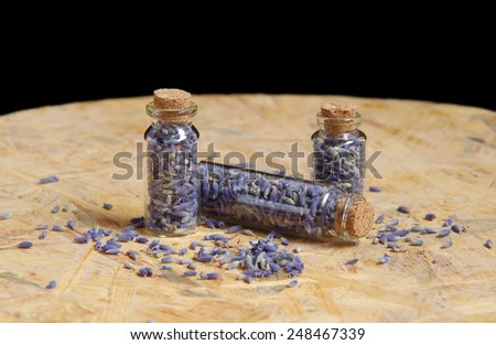 Dried lavender flowers in glass bottles on a wooden table