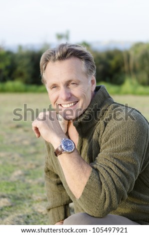 handsome mature blond man in his forties wearing a wrist watch