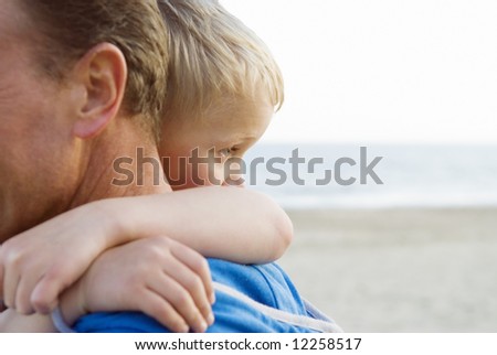 A young boy cuddles his father.