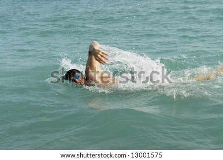 A man swimming the front crawl in the sea.