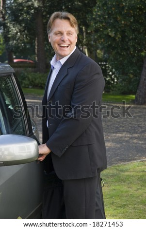 Handsome forties businessman is opening his car door and on his way to work
