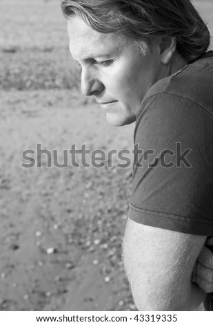 A black and white portrait photo of a depressed and lonely looking mature man in his forties