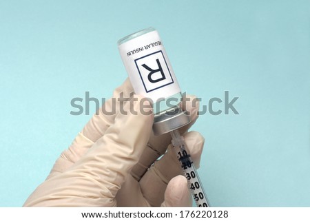 Nurse draws regular insulin from vial with insulin syringe.