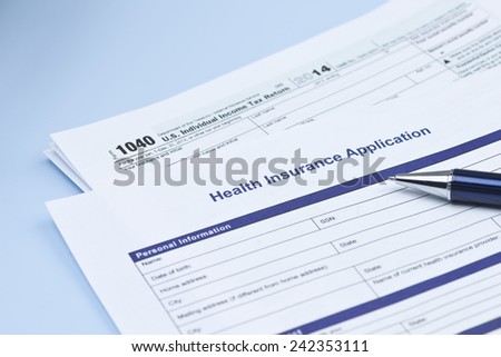 Health insurance application with United States 1040 tax form and pen.