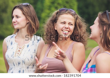 three girls walking and laughing in the park