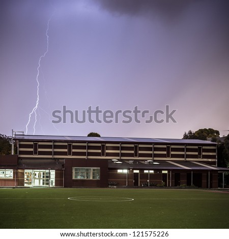 Lightning strike over public school building and sporting field.