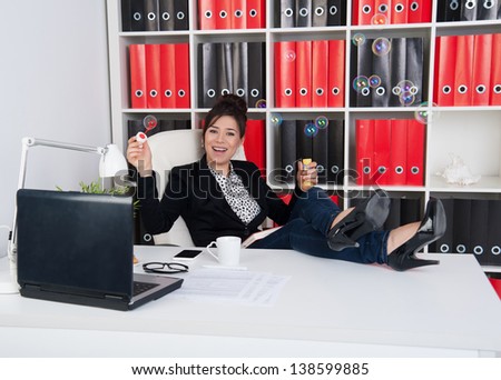 business woman in office hours blowing soap bubbles in the office