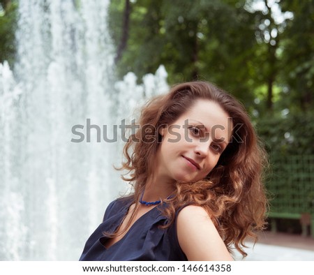 Stunning woman on the background of the fountain in summer
