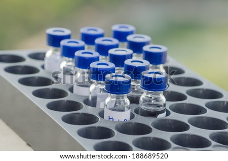 Sample vial in the  instrumental analysis tray on blur green background