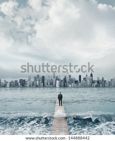 man standing on a boardwalk and looking at the city on a horizon