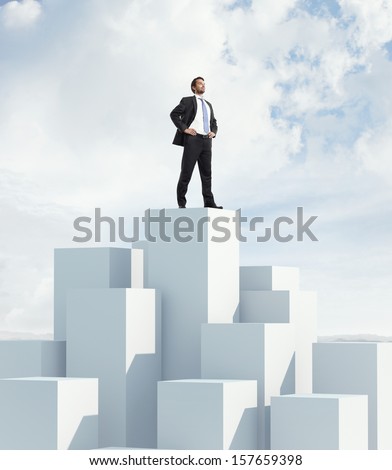 Businessman standing on highest cube