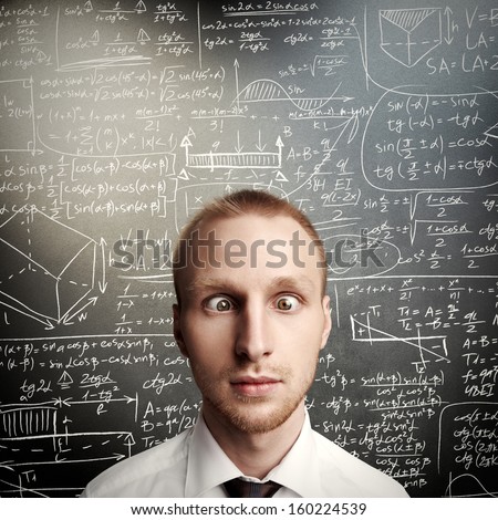 thinking young man against desk with formulas