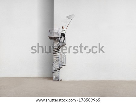 Business man standing on a ladder with butterfly net in his hands