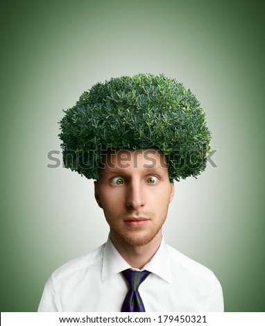 Young cross-eyed man with green bush instead hair