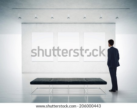 Gallery room and man looking at empty frames