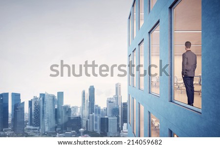 Businessman looking at city through window